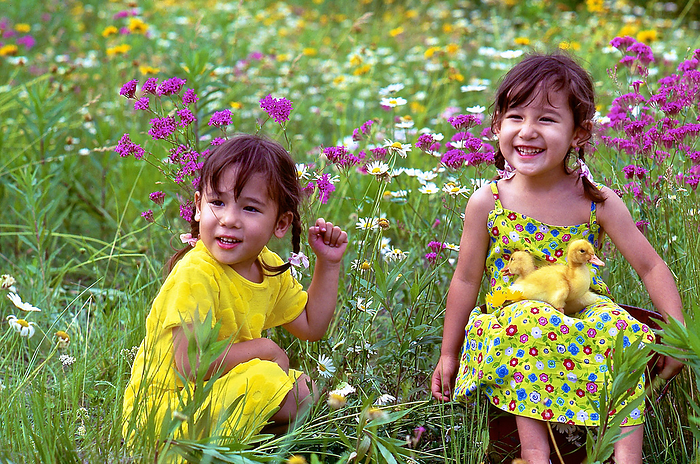 Children playing in a flower garden in early summer