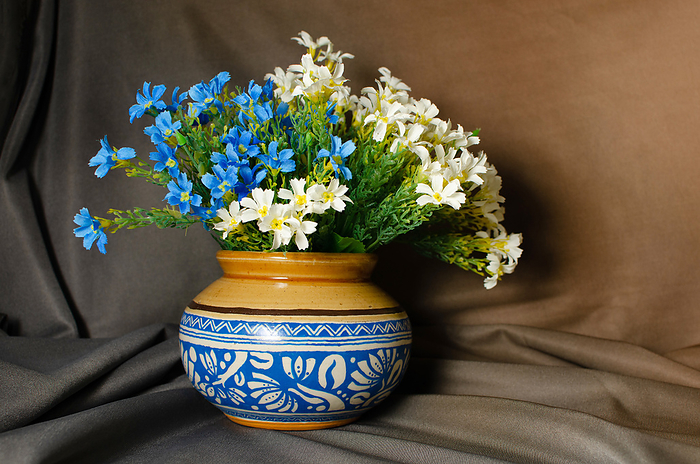 Traditional ceramic pot with Blue design and flowers on Brown background Traditional ceramic pot with Blue design and flowers on Brown background, by Zoonar RealityImages