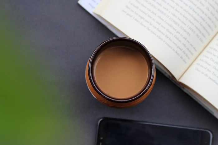 Top view of tea or chai with book and phone. Tea time, India Top view of tea or chai with book and phone. Tea time, India, by Zoonar RealityImages
