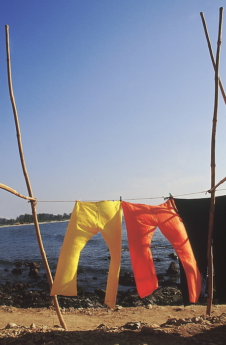 Bright trousers hanging out to dry on the seashore. Bright trousers hanging out to dry on the seashore., by Zoonar RealityImages