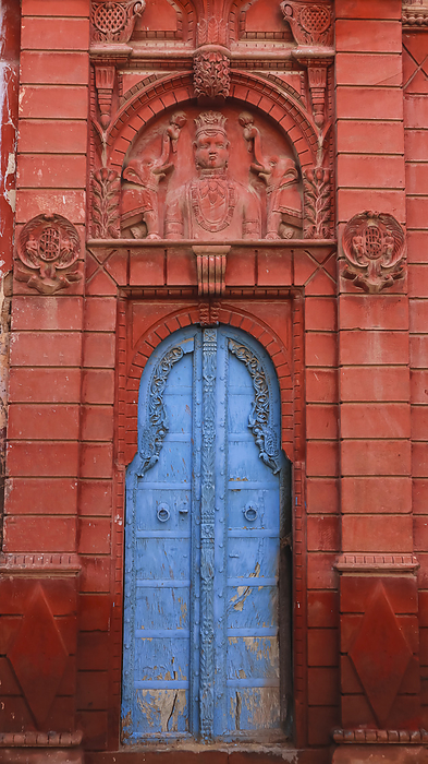 Beautifully carved red Houses with blue Doors on the Street of Bikaner, Rajasthan, India. Beautifully carved red Houses with blue Doors on the Street of Bikaner, Rajasthan, India., by Zoonar RealityImages