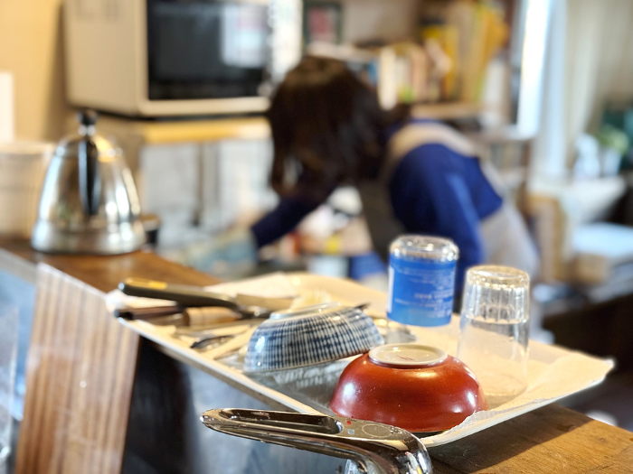 Woman cleaning behind dishes