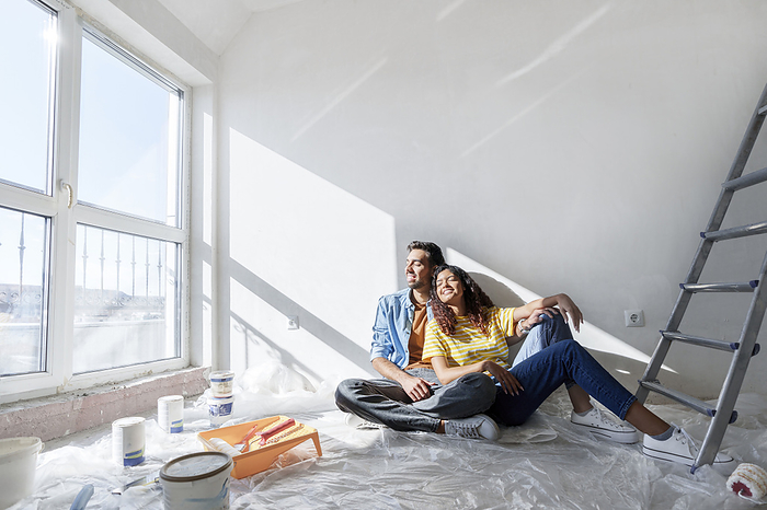 Happy couple sitting on floor at new home