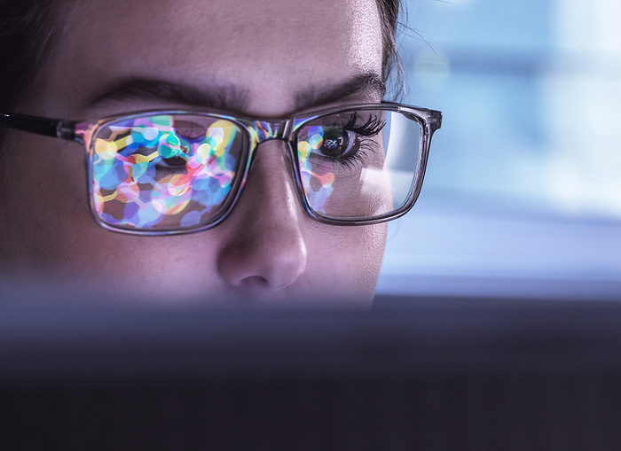 Scientist wearing eyeglasses and analyzing biochemical data on computer