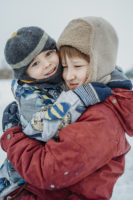 Cute brothers embracing in snow
