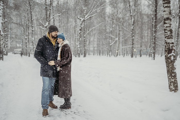 Mature couple standing in snow at park