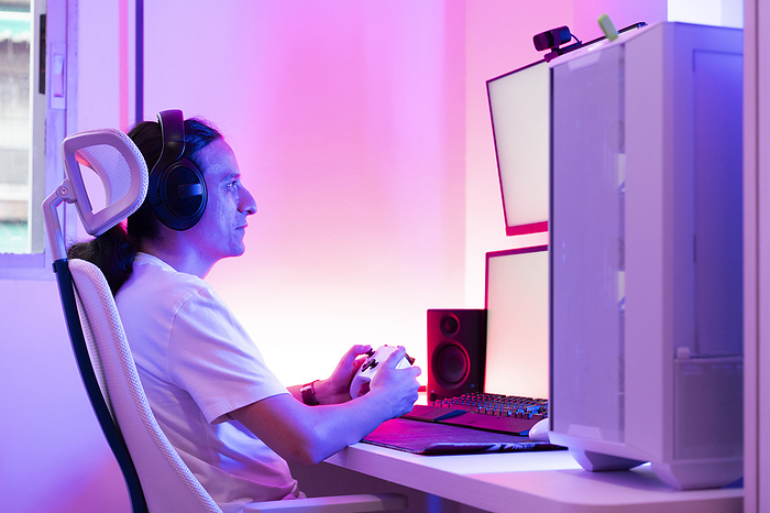 Gamer using gamepad and playing video game at gaming station