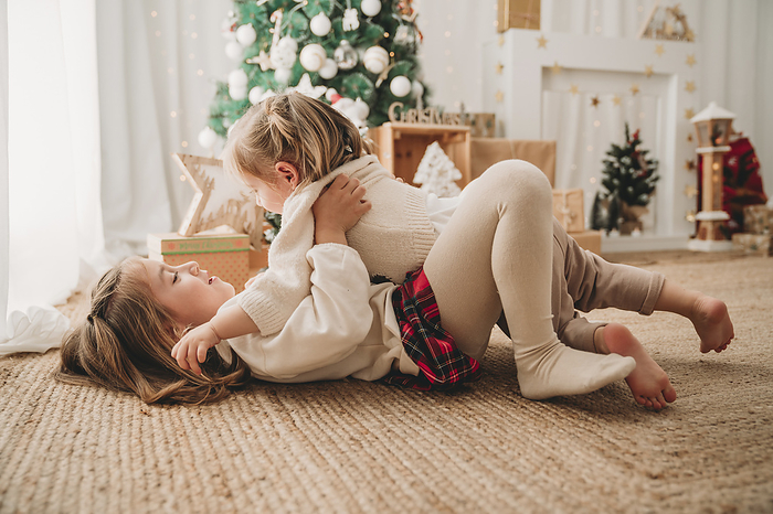 Happy girls playing and enjoying near Christmas decoration