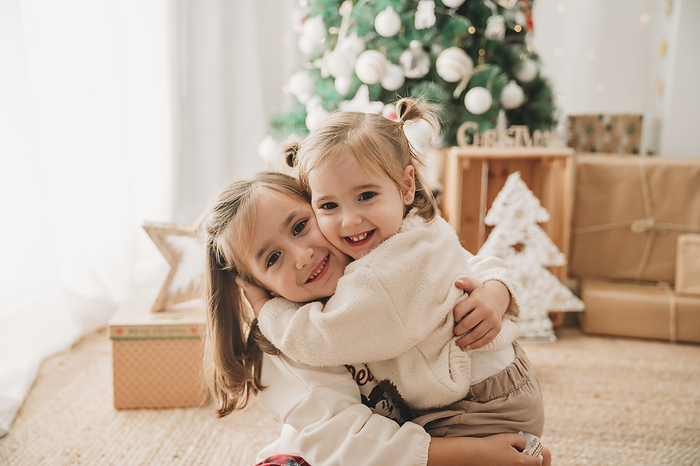 Girl hugging sister in living room at home