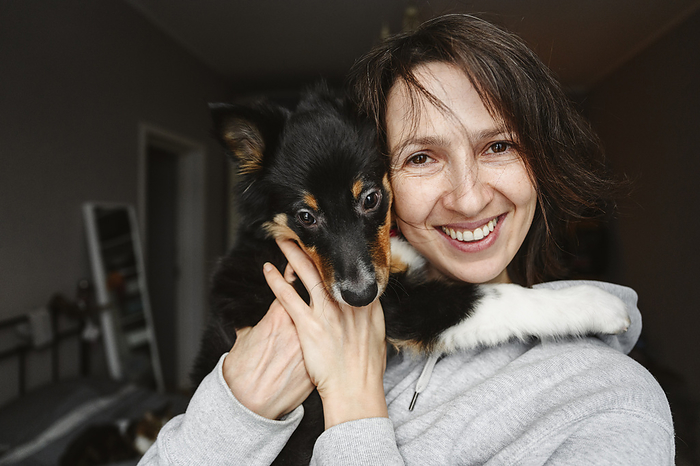 Smiling woman with dog at home