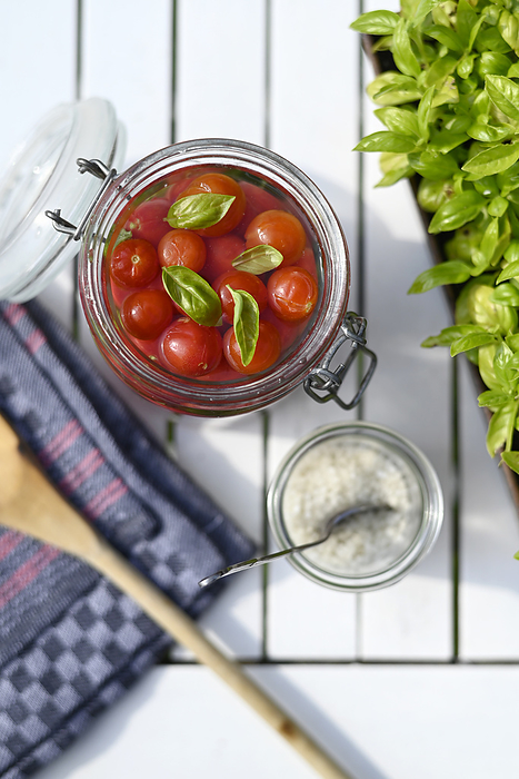 pickle vegetables Preserved tomatoes in jar with basil leaves