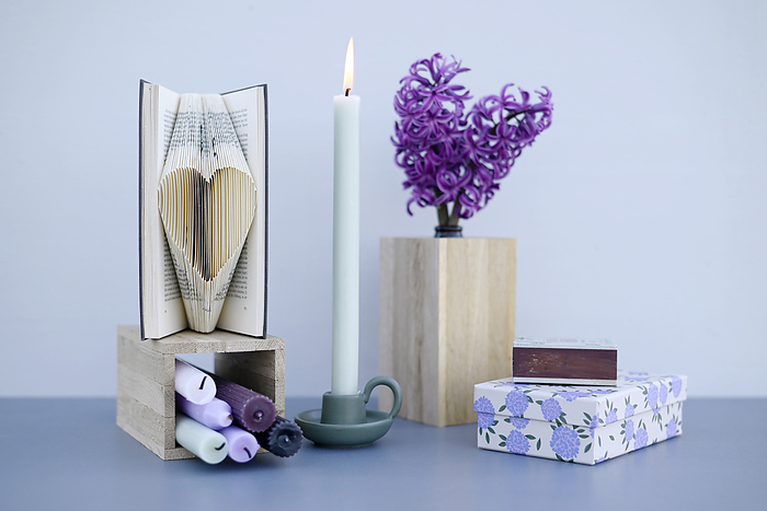 valentine s day decoration Studio shot of burning candle, blooming hyacinths and heart carved in book pages