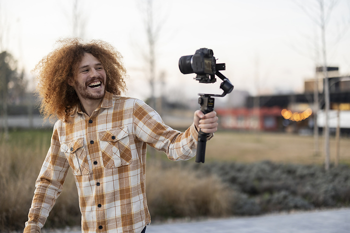 Happy influencer vlogging through camera
