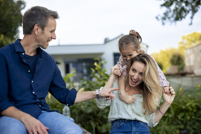 Cheerful family having fun together in front of house