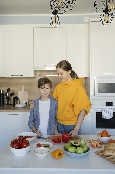 Siblings standing near kitchen island at home