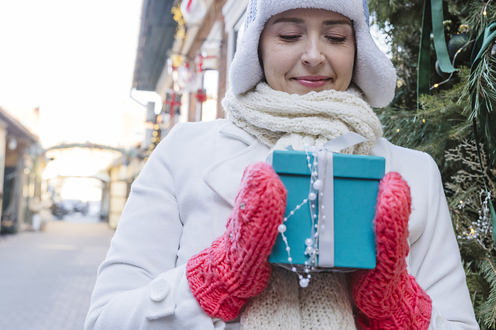 Woman looking at decorated gift box in Christmas