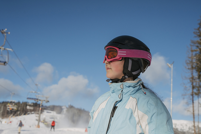 Girl wearing sports helmet at ski resort