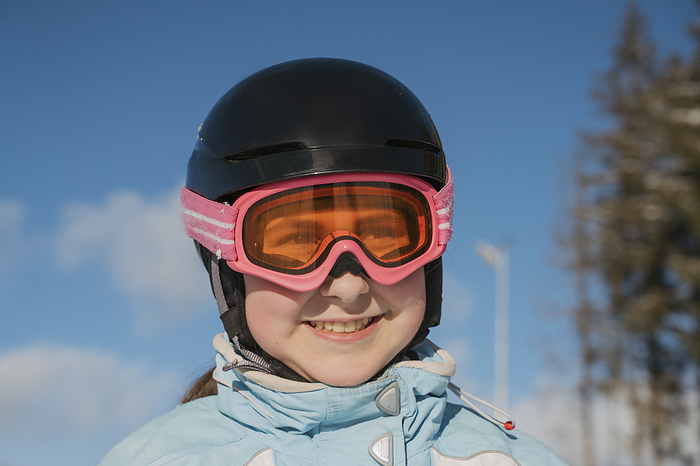 Smiling girl wearing ski goggles at resort