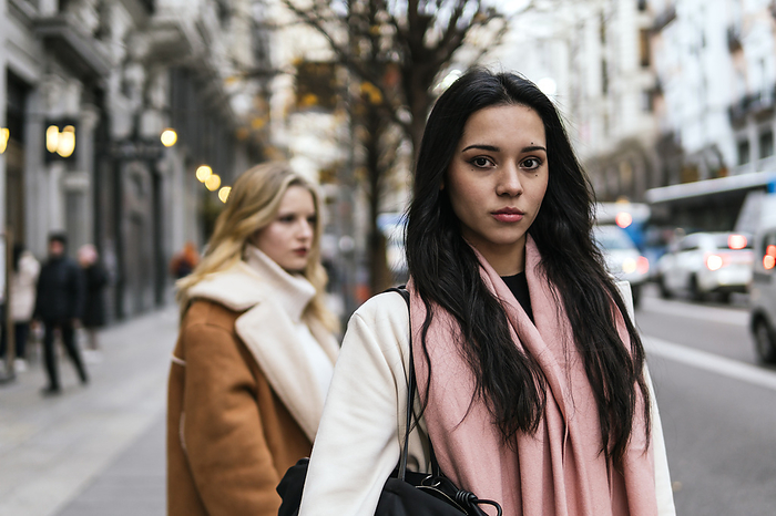 Young woman with friend standing at street in background