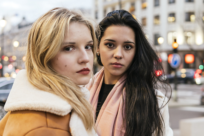 Serious blond woman with friend in city