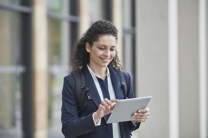Business woman Smiling curly haired businesswoman using tablet PC