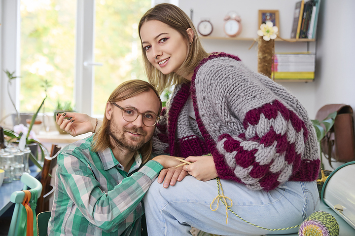 Smiling woman sitting with man at home