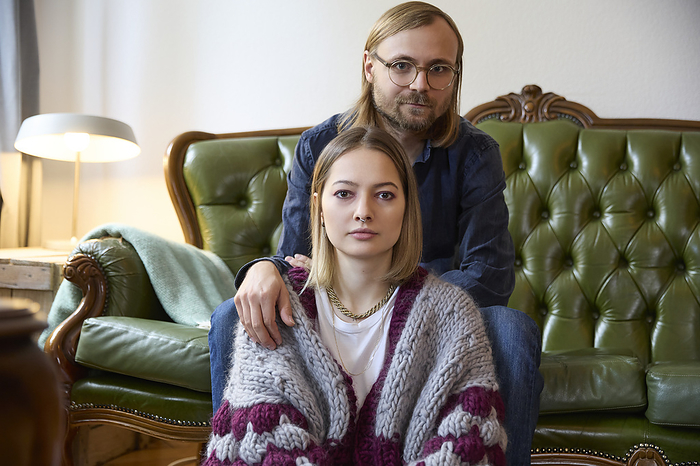 Woman with man sitting on sofa at home