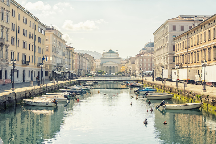Canal Grande in Trieste with reflection and Piazza and Church of Sant Antonio Nuovo, Trieste, Italy Italy, Friuli Venezia Giulia, Trieste, Boats moored along Canal Grande in summer