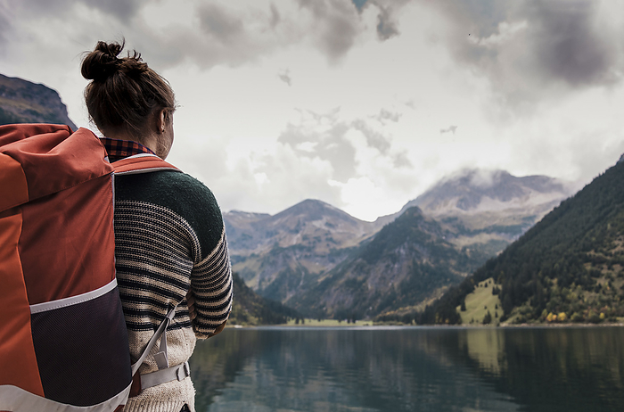 Woman with backpack in front of lake Vilsalpsee and mountains at Tyrol, Austria
