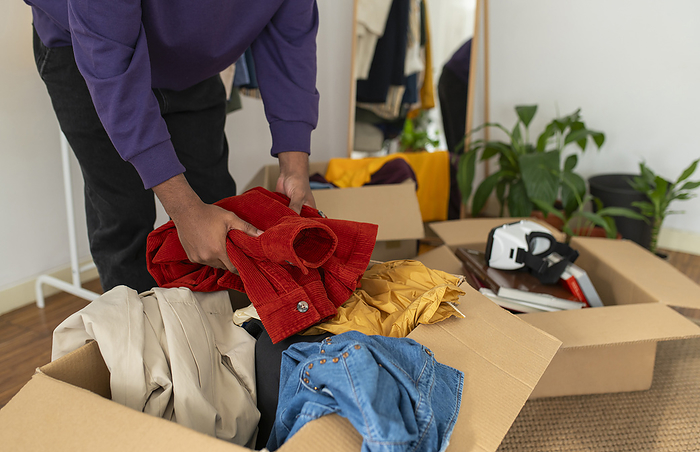Man decluttering clothes at home