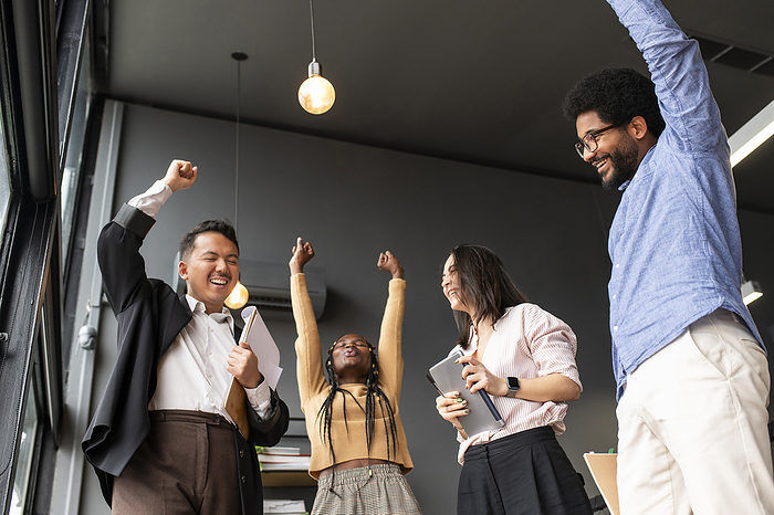 Cheerful business people celebrating success in office