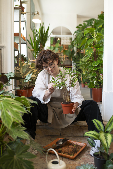 Botanist examining plant sitting at plant shop