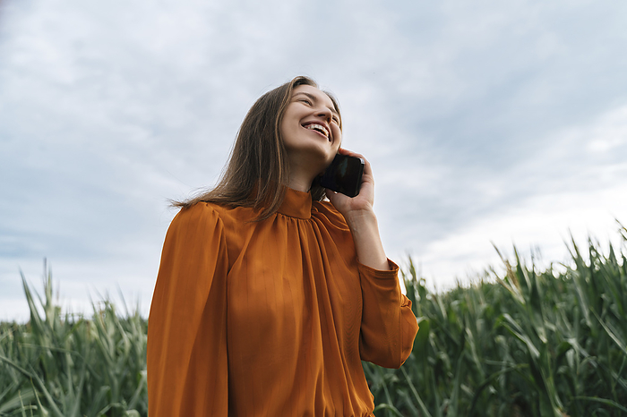 Woman talking on mobile phone in corn field