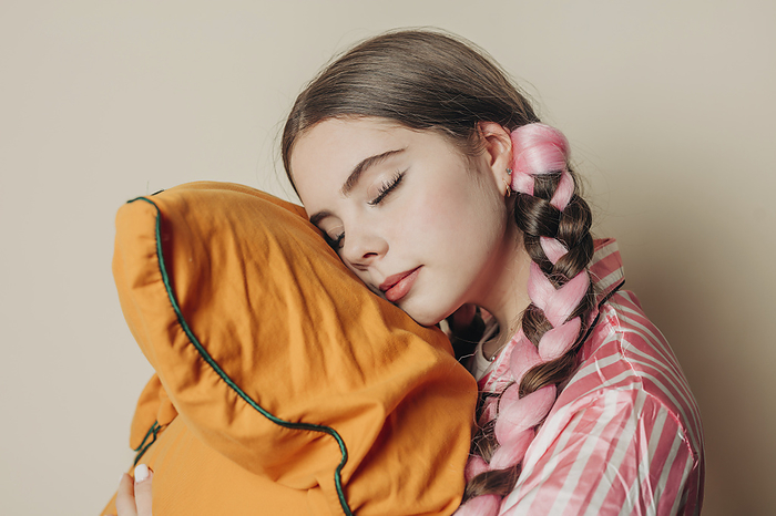 Woman sleeping on yellow pillow near wall