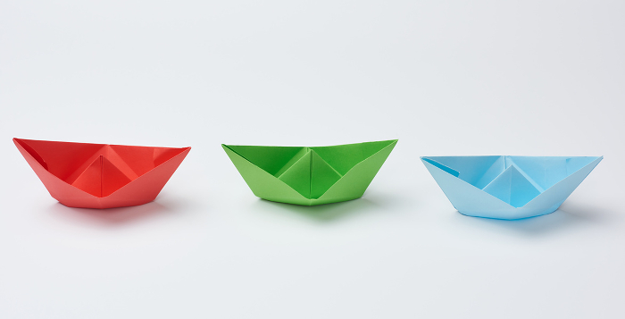 Three paper boats on a white background, close up Three paper boats on a white background, close up