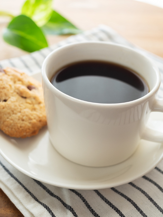 Hot coffee and chocolate cookies in a white cup