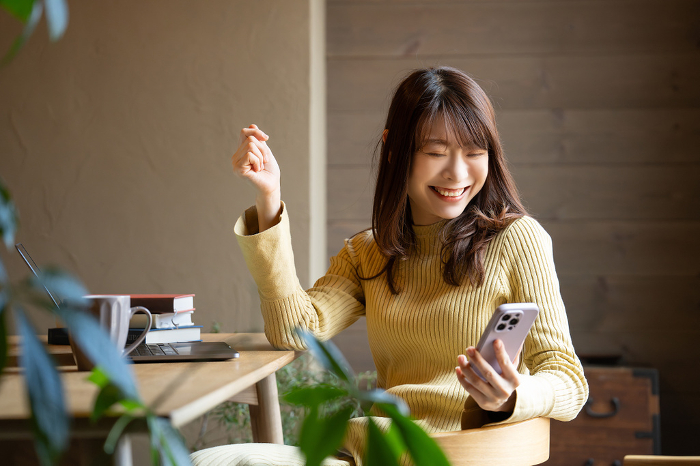 Smiling Japanese woman using a smartphone (People)