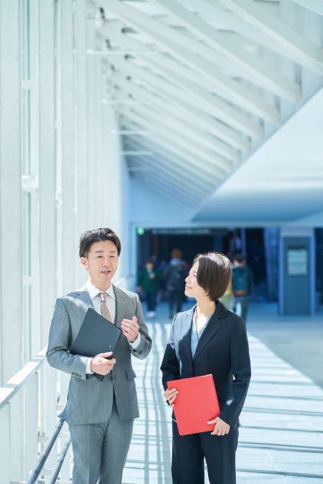 Japanese man and woman in suits conversing (People)