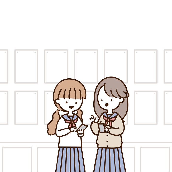 Two girls in school uniform exchanging contact information while operating a smartphone in a classroom.
