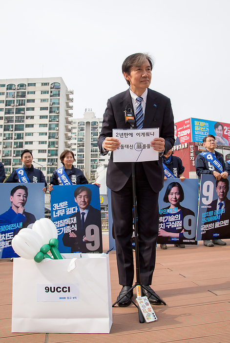2024 South Korea General Election: The Rebuilding Korea Party Cho Kuk, April 6, 2024 : Cho Kuk, leader of the Rebuilding Korea Party  aka the Korea Innovation Party  for proportional representation seats, holds a sign which a supporter prepared at the party s meeting with supporters in Seoul, South Korea, ahead of the April 10 general elections. The sign reads,  What the hell in two years  after President Yoon Suk Yeol s inauguration . Cast a vote instead of a stone . Mock green onions in a mock Gucci bag which a supporter prepared for Cho s birthday celebration are seen. The mock green onions makes a parody of South Korean President Yoon Suk Yeol who aroused anger by finding the price tag of 875 won   0.65  for a bunch of green onions a  reasonable price  at a grocery mall last month. The 875 won   0.65  was a temporary discount price offered due to a government subsidy and the average retail prices of green onions was about 3,000 to 4,000 won   2.2 to 2.9  for weeks, which was some of the highest levels over the years. The signs on a mock Gucci bag read,  Rather than Dior... Vote for 9  the electoral symbol of the Rebuilding Korea Party  . The symbol of  9UCCI  is pronounced in Korean similarly to Gucci, luxury fashion brand, as  9  is pronounced as  Gu . The sign makes a parody of a scandal of South Korea s first lady Kim Keon Hee who received a luxury Dior bag as a  gift  in 2022. Cho Kuk, South Korea s former Justice Minister under the previous liberal Moon Jae In administration, was an architect of the liberal government s prosecution reform.  Photo by Lee Jae Won AFLO 