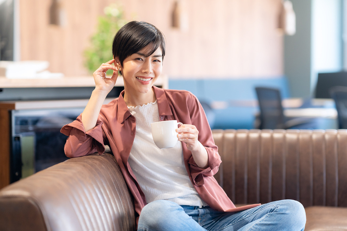 Young Japanese woman drinking coffee at a cafe (People)