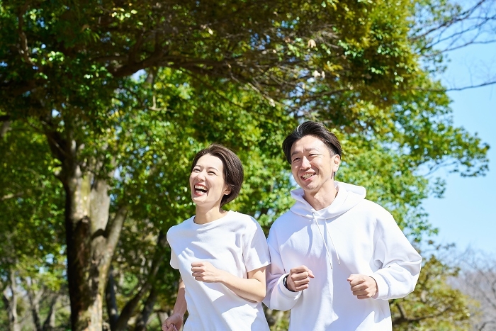 Japanese man and woman running side by side outdoors (People)