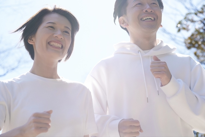 Japanese man and woman running side by side outdoors (People)