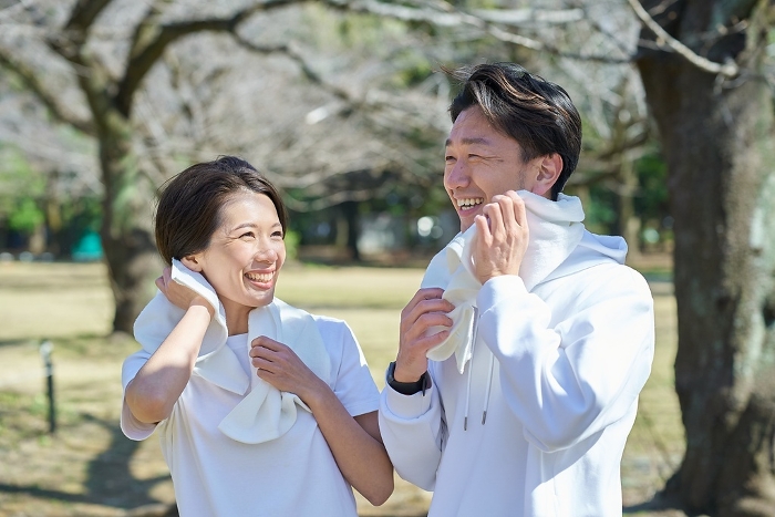 Japanese man and woman wiping sweat after exercise (People)