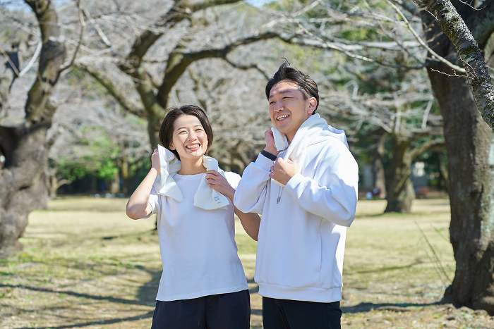 Japanese man and woman wiping sweat after exercise (People)