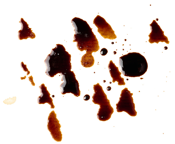 Spilled black coffee, splashes on a white background, close up Spilled black coffee, splashes on a white background, close up