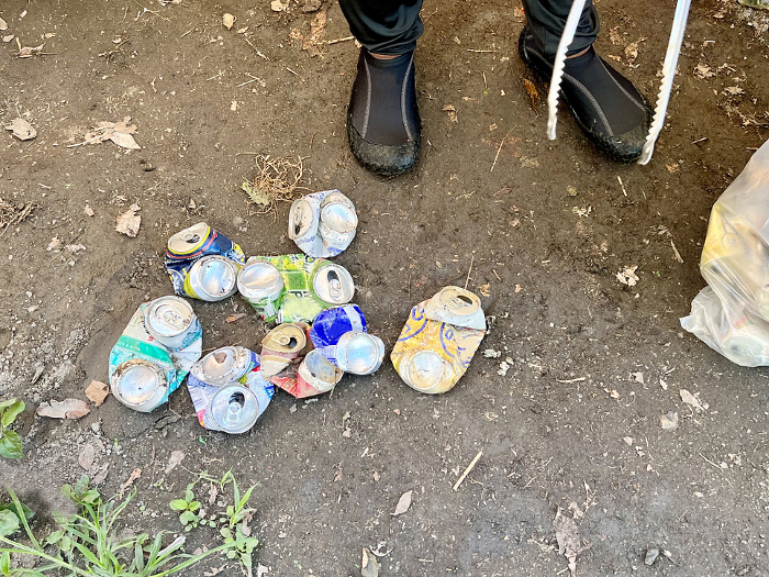 The feet of people picking up empty cans
