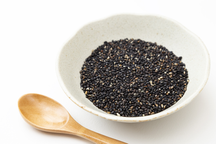 Black sesame seeds on white background