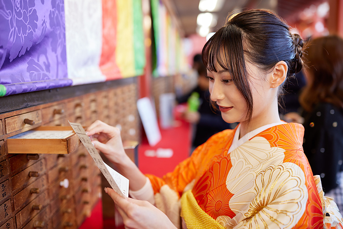 Japanese woman in furisode kimono drawing a fortune