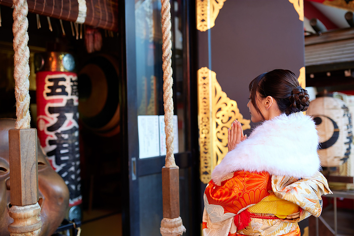 Japanese woman in furisode (long-sleeved kimono) paying a visit to a shrine